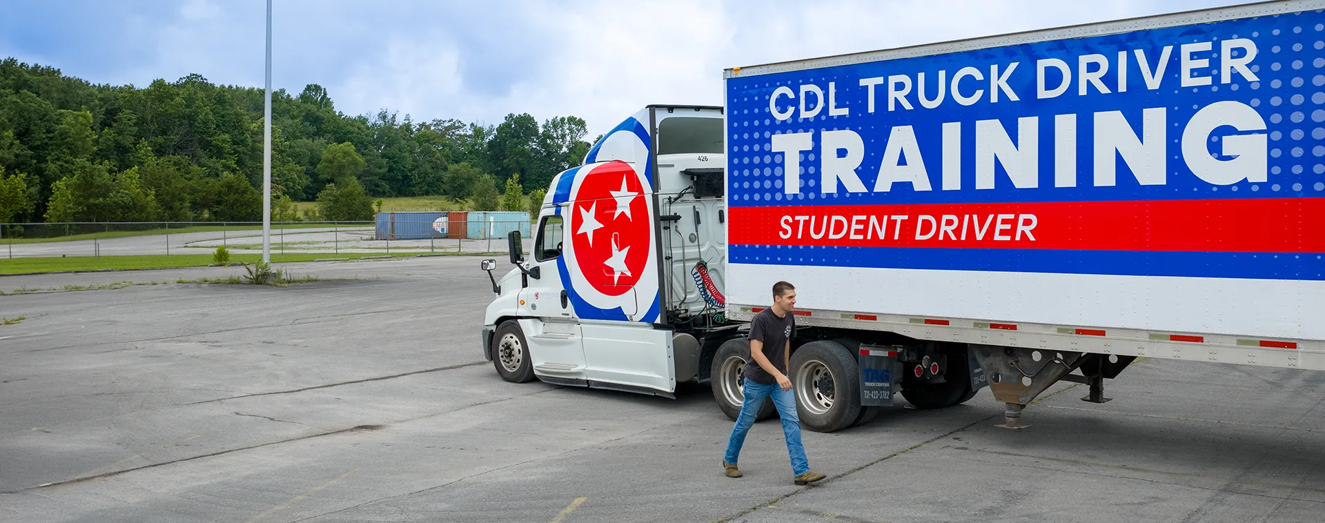 CDL training semi truck with Tennessee logo and &ldquo;CDL Truck Driver Training Student Driver&rdquo; text parked in open lot.